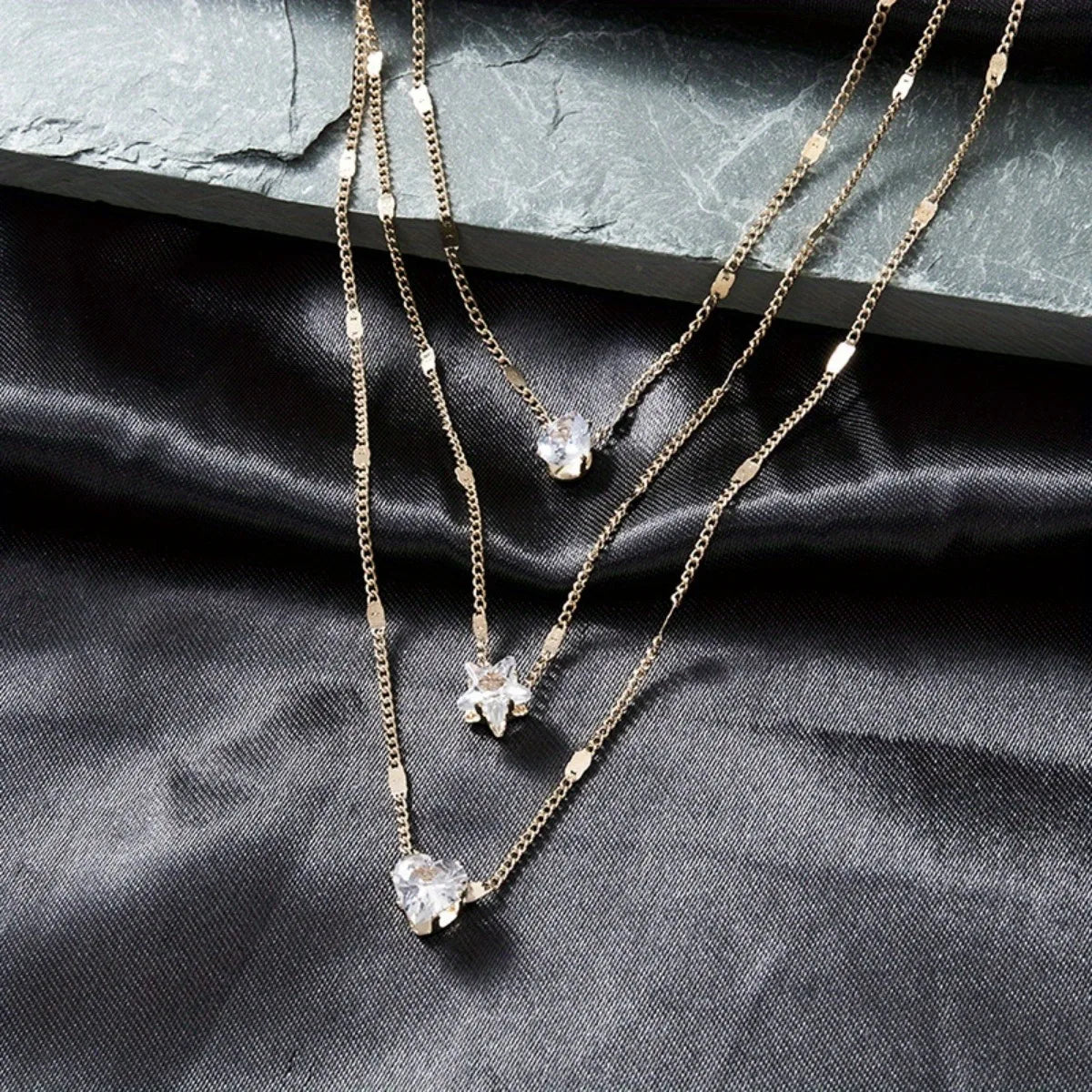 Chic layered necklace – star, heart, and drop details in harmony.